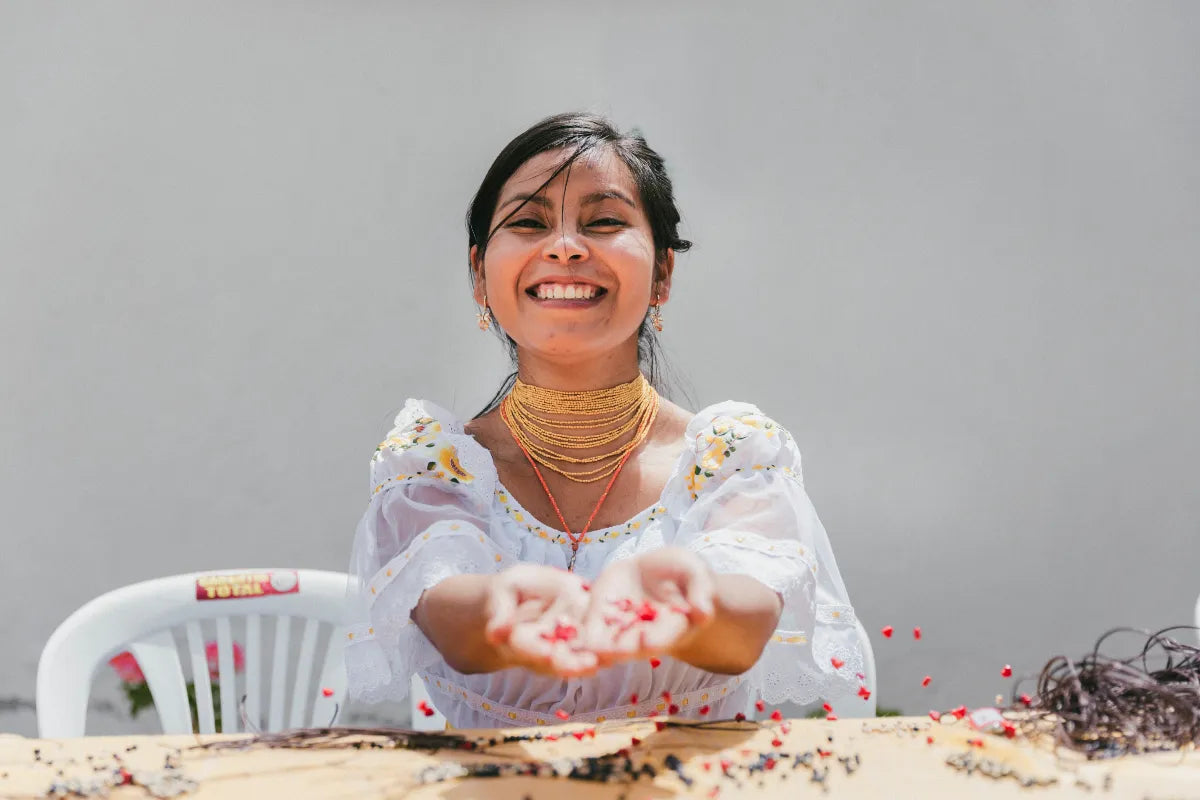 Woman holding small objects with a neutral background