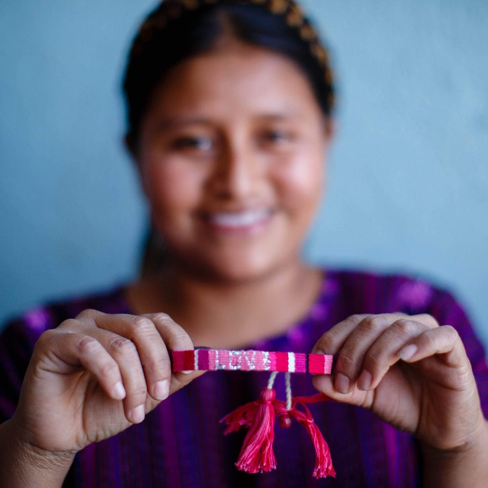 An artisan holding an ATITLAN LOVE Bracelet - PINK & RED - Love Is Project