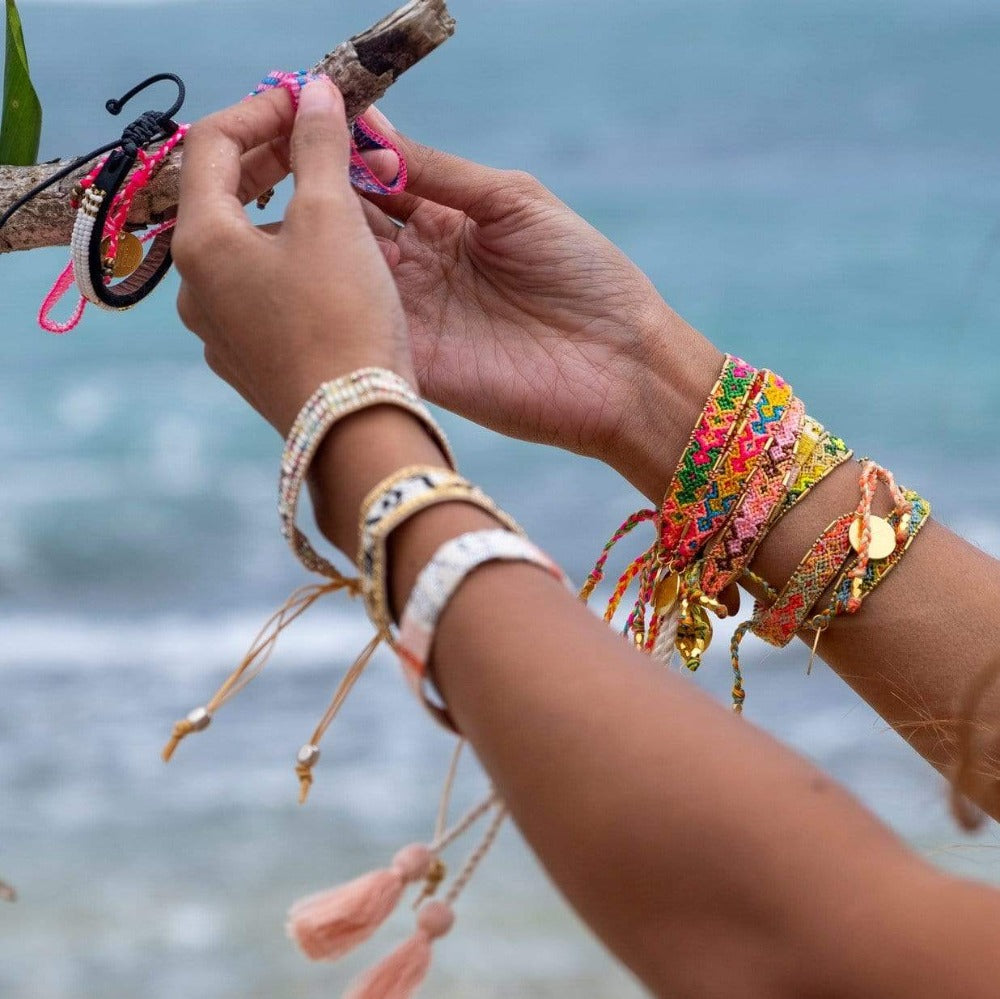 A model wearing stacks of the Jungle Bloom Bali Friendship Bracelet from Love Is Project