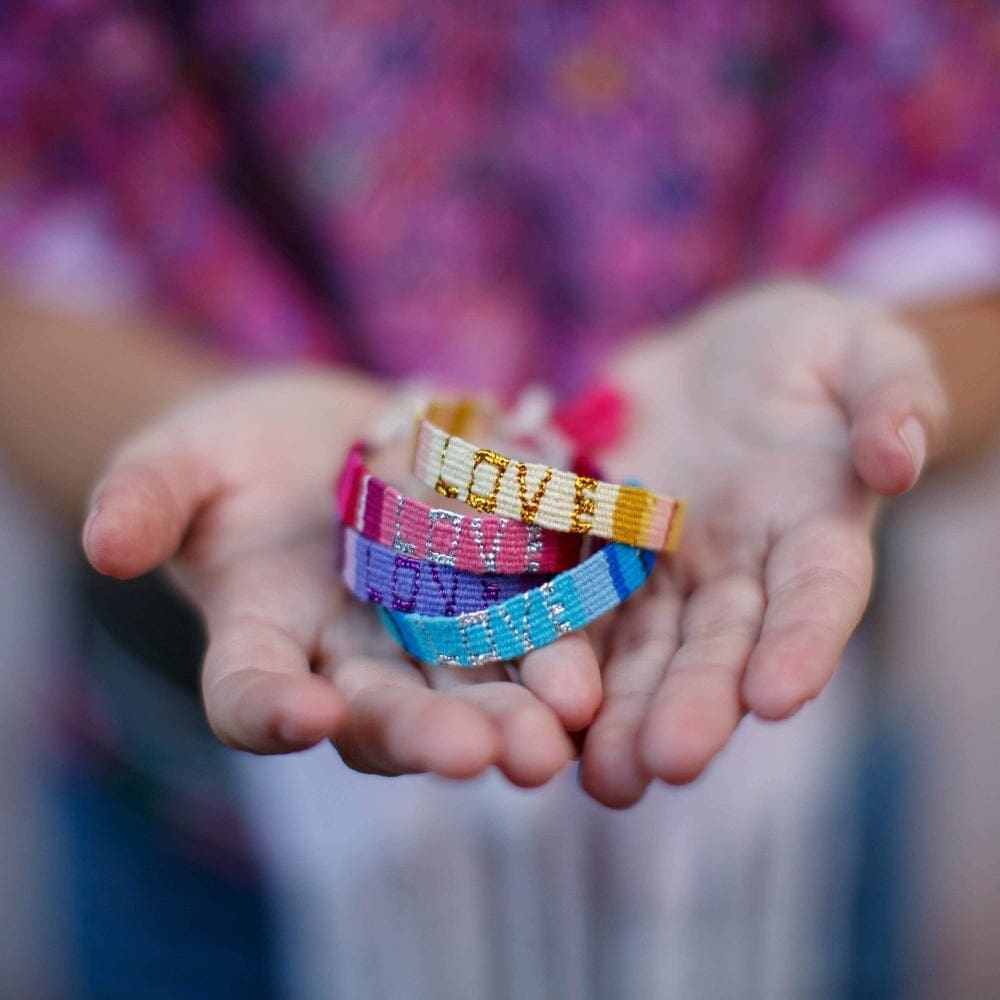 An artisan holds a stack of Atitlan LOVE Bracelets