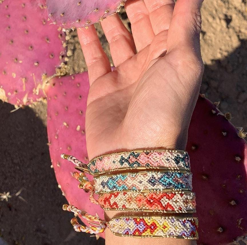 A model with a cactus wearing the Desert Bali Friendship Bracelet Bundle from Love Is Project