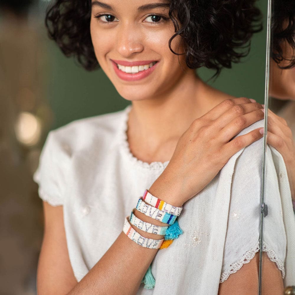 A model wears the Blue and White Atitlan LOVE Bracelet from Love Is Project