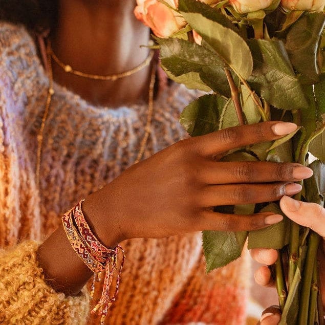 Model wearing the Glow Lava friendship bracelet from Love Is Project